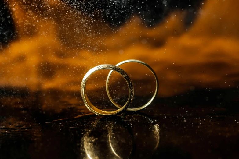 a couple of wedding rings sitting on top of a table, avatar image, gold dust, profile image, ice and fire