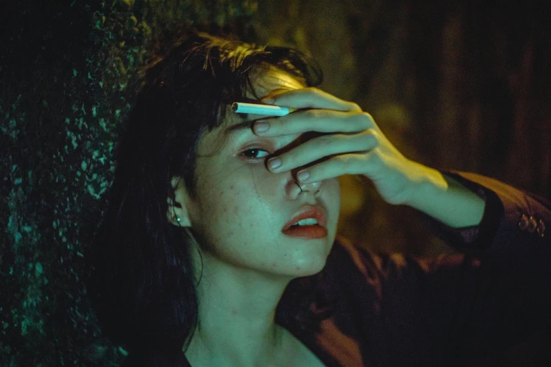 a woman holding a cigarette in her hand, inspired by Elsa Bleda, pexels contest winner, hyperrealism, 8 0 s asian neon movie still, wet eye in forehead, in a forest at night, facepalm