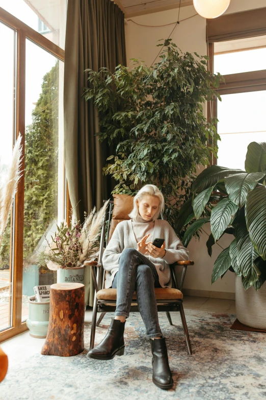 a woman sitting in a chair reading a book, trending on pexels, fine art, tall plants, girl making a phone call, white haired lady, low fi