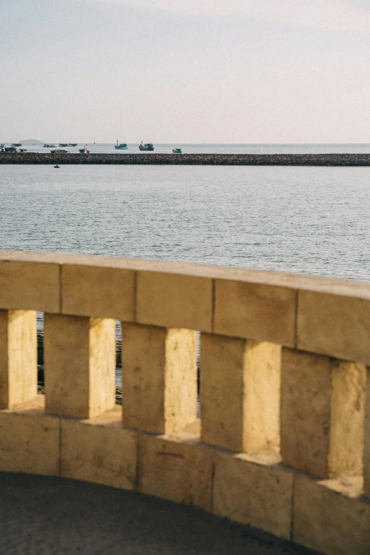 a man riding a skateboard on top of a cement wall, viewed from the ocean, arab ameera al-taweel, small dock, overlooking