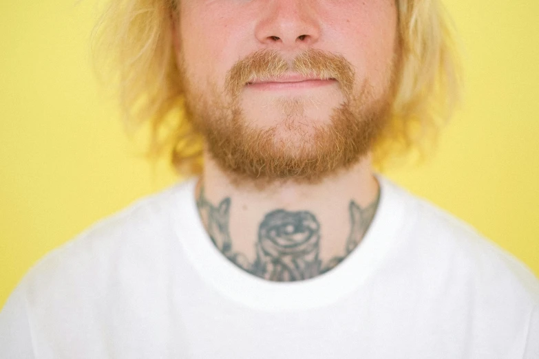 a man with a tattoo on his neck, inspired by Seb McKinnon, trending on pexels, light yellow hair, unkempt beard, mid length portrait photograph, clean linework