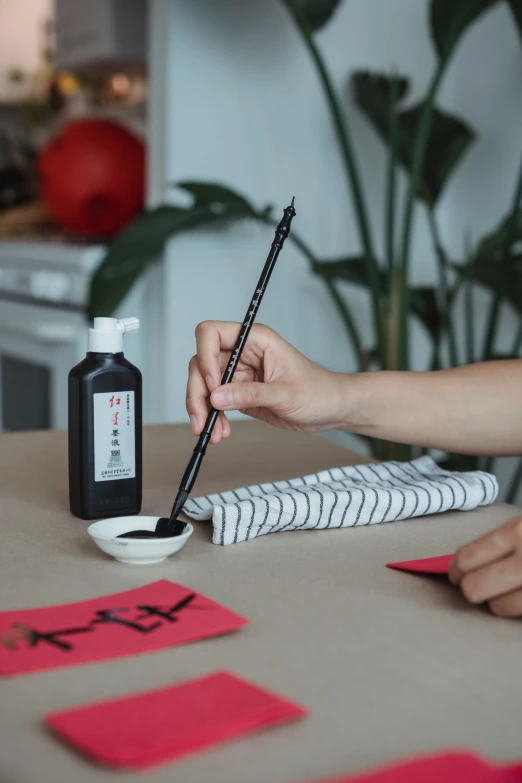 a person sitting at a table writing on a piece of paper, inspired by Qian Du, modern european ink painting, made of smooth black goo, handcrafted, at home, 💣 💥