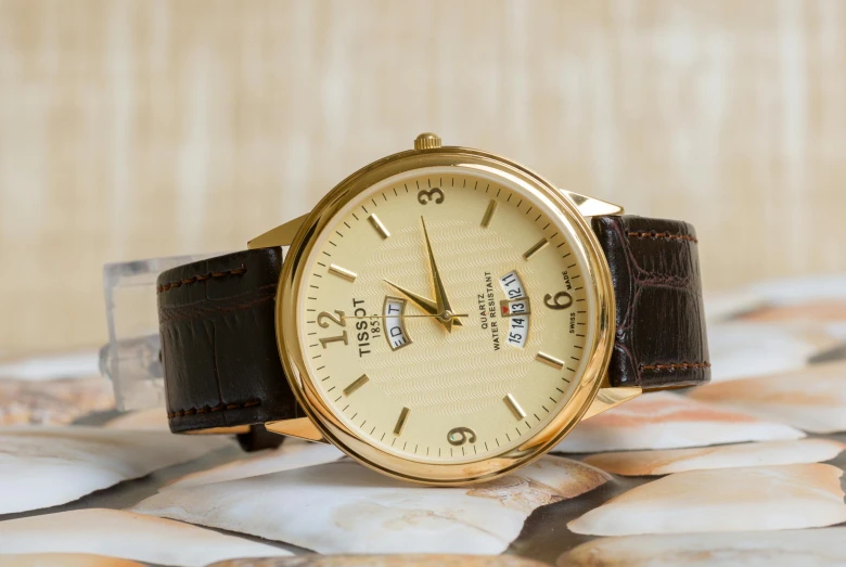 a close up of a watch on a table, inspired by Eliseu Visconti, pexels contest winner, brown and gold color palette, upscaled to high resolution, birch, a pair of ribbed