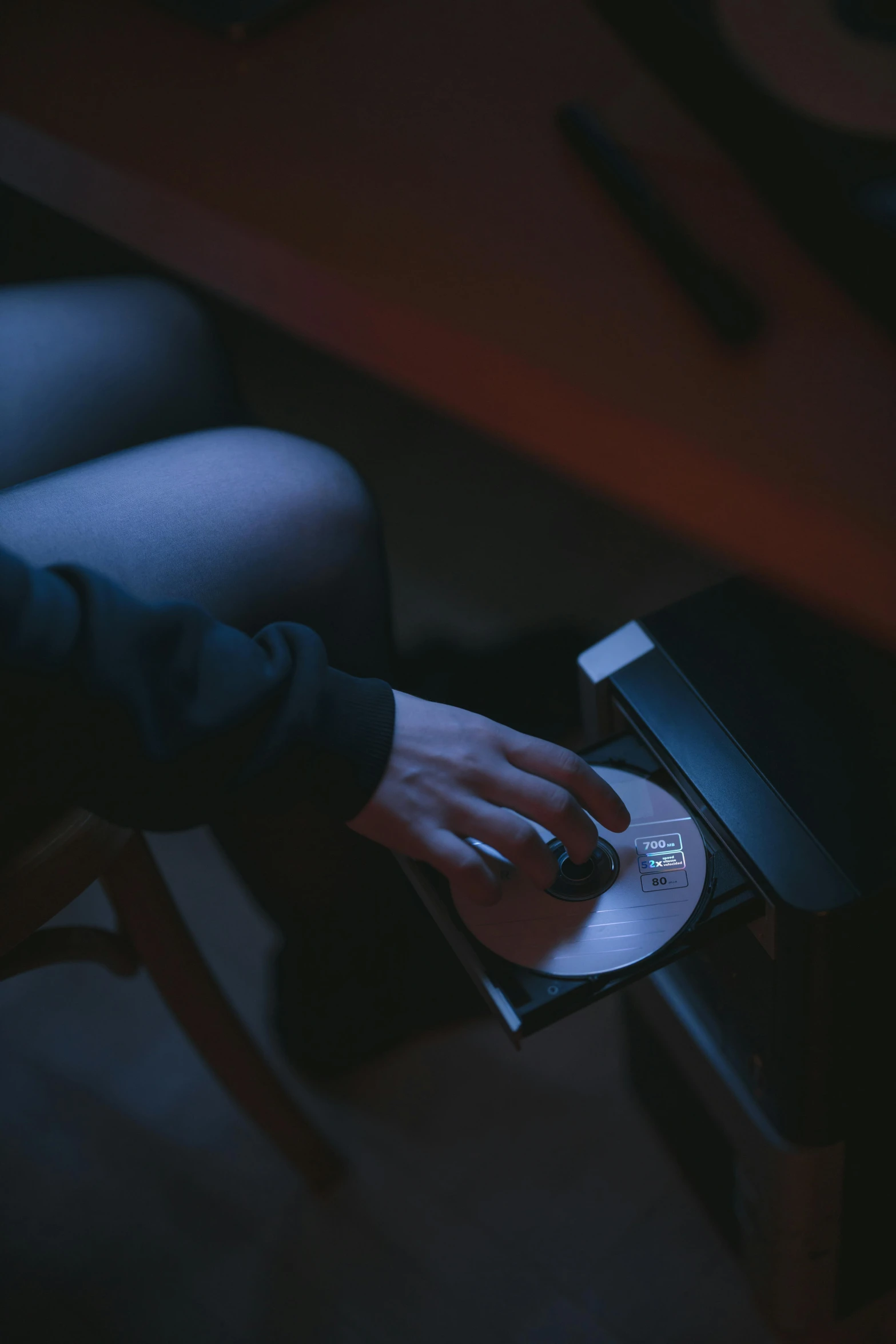 a person using a laptop in a dark room, an album cover, inspired by Elsa Bleda, unsplash, holography, holding scale, sitting on the floor, high angle close up shot, a seance