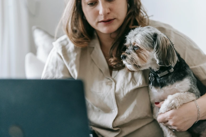 a woman sitting on a couch holding a small dog, trending on pexels, renaissance, sitting at a computer, avatar image, professional image, close up to the screen