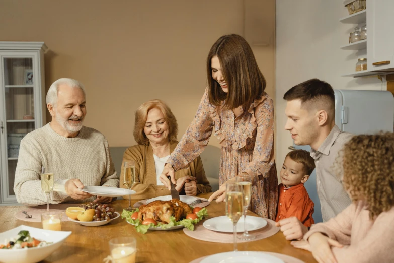 a group of people sitting around a wooden table, dinner table