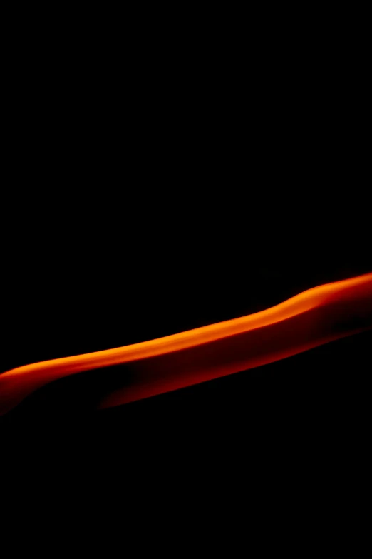 a close up of a toothbrush on a black background, a picture, by Doug Ohlson, red glowing streams of lava, sleek interceptor profile, curves, orange lit sky