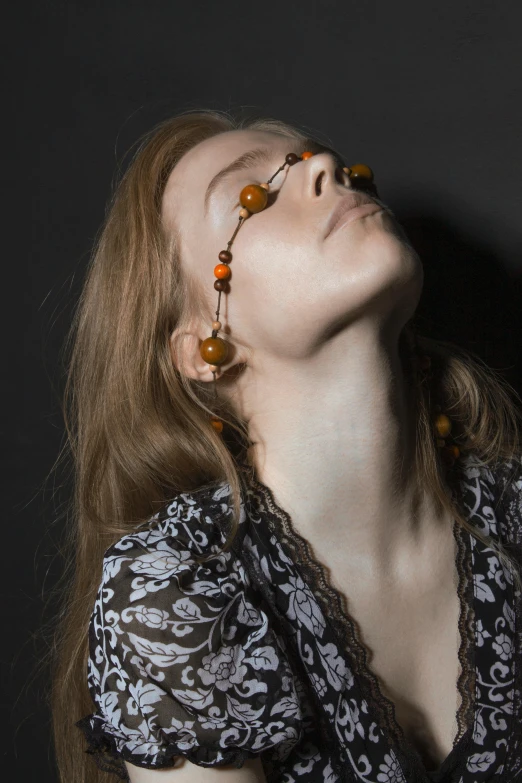 a woman with glasses looking up into the sky, inspired by Anna Füssli, renaissance, amber jewelry, dark orange, 2010s, forehead jewelry