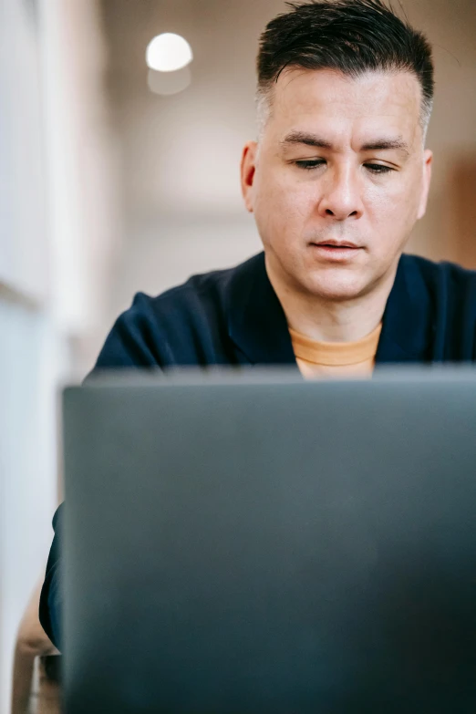 a man sitting in front of a laptop computer, by Carey Morris, pexels, renaissance, bald lines, wearing a dark blue polo shirt, temuera morrison, thumbnail