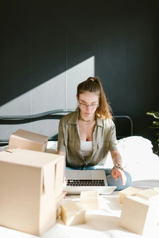 a woman sitting on a bed working on a laptop, pexels contest winner, renaissance, delivering packages for amazon, profile image, low sun, inspect in inventory image