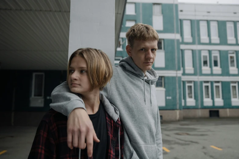 a man and a woman standing next to each other, an album cover, by Emma Andijewska, pexels contest winner, realism, young boy, looking threatening, reykjavik junior college, movie still 8 k