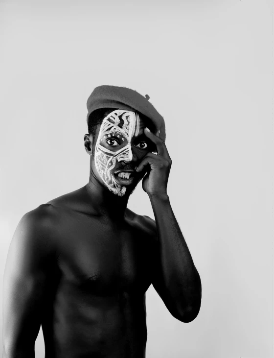 a man with a painted face talking on a cell phone, a black and white photo, by Dean Ellis, pexels contest winner, afrofuturism, pose 4 of 1 6, saatchi art, bodypainting, face with artgram