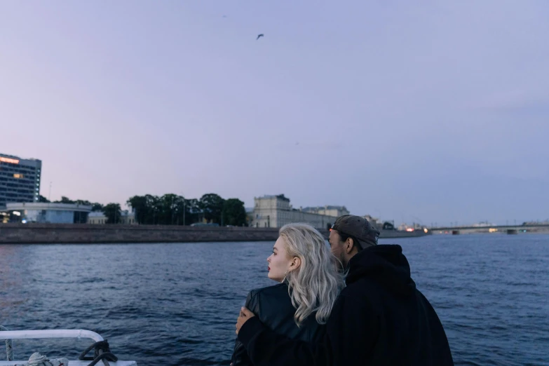 a man and a woman on a boat looking out at the water, by Grytė Pintukaitė, pexels contest winner, visual art, saint petersburg, elle fanning at night, pale sky, soft light.4k