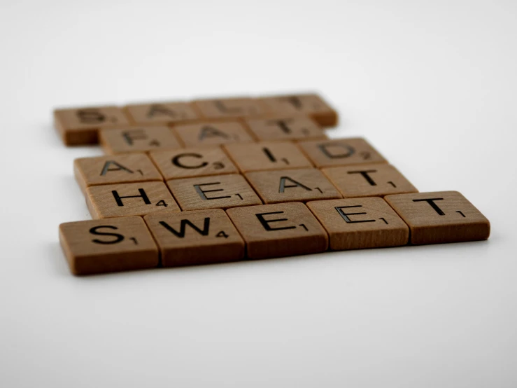 a couple of scrabbles sitting on top of each other, by Sylvia Wishart, unsplash, letterism, silent hill game, acids, studio shoot, close up shot from the side