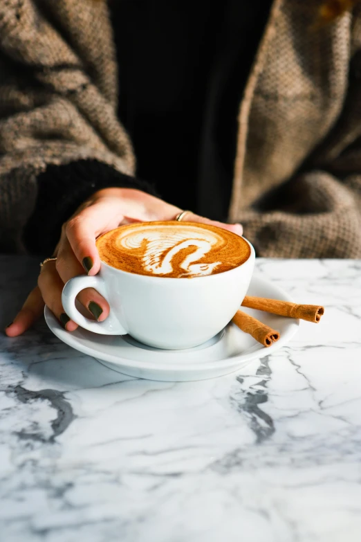 a person sitting at a table with a cup of coffee, all marble, cinnamon, daily specials, thumbnail