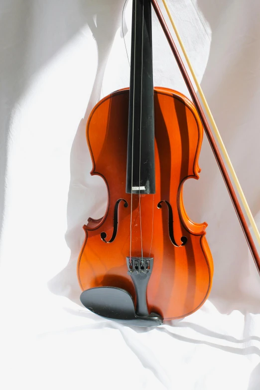 a violin sitting on top of a white sheet
