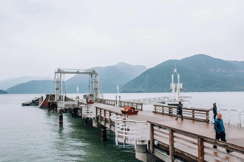 a person standing on a pier next to a body of water, pexels contest winner, mingei, in hong kong, ai weiwei and gregory crewdson, family friendly, small port village