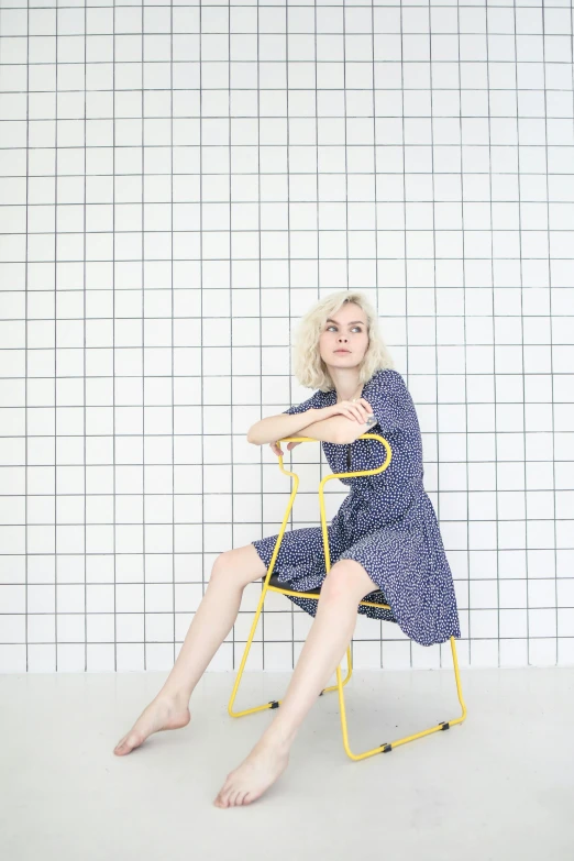 a woman in a blue dress sitting on a yellow chair, pexels, conceptual art, delicate patterned, britt marling style 3/4, grey, gif