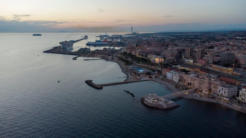 a large body of water next to a city, by Carlo Martini, pexels contest winner, seaview, evening light, aerial footage, spanish