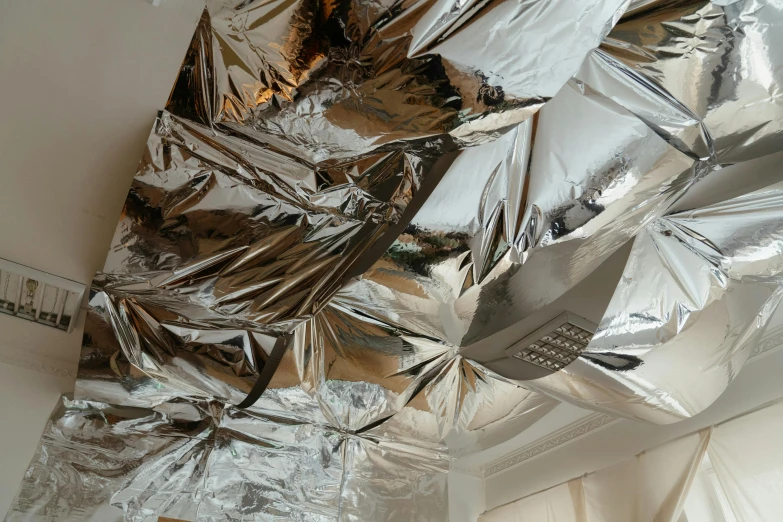 a piece of aluminum foil hanging from the ceiling, inspired by Cornelia Parker, unsplash, collapsed ceiling, jen atkin, chrome accents, max hay