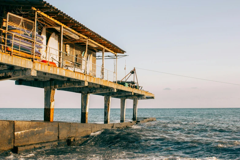 a man standing on top of a pier next to the ocean, huts, nika maisuradze, people angling at the edge, ocean dept