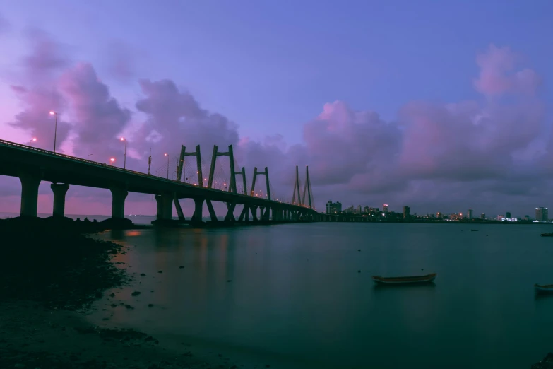 a long bridge over a body of water, pexels contest winner, romanticism, in sci - fi mumbai, purple sky, humid evening, brown