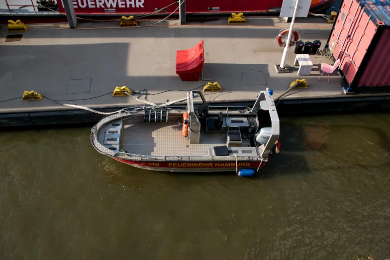 a small boat sitting on top of a body of water, by Schelte a Bolswert, pexels contest winner, hurufiyya, flying emergency vehicles, hell gate, three quarter view, on the deck of a ship