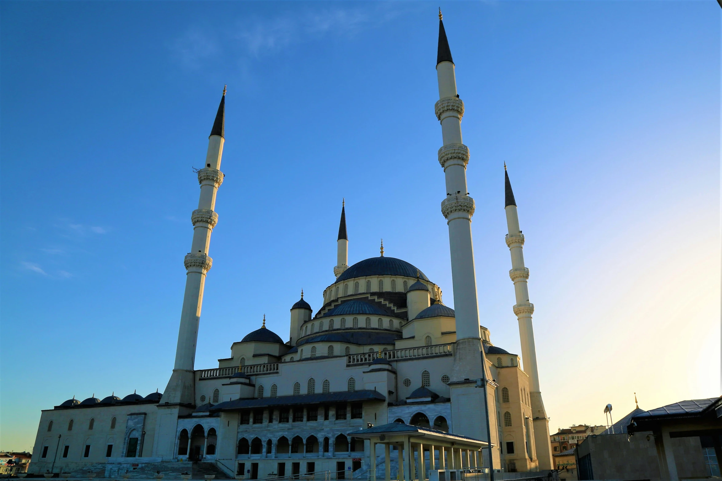 a large white building sitting on top of a grass covered field, inspired by Altoon Sultan, pexels contest winner, hurufiyya, spires, blue, square, full morning sun