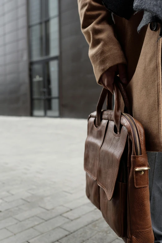 a man in a brown coat carrying a brown bag, by Daarken, trending on pexels, modernism, holding a briefcase, layered texture, highly detailded', connectivity