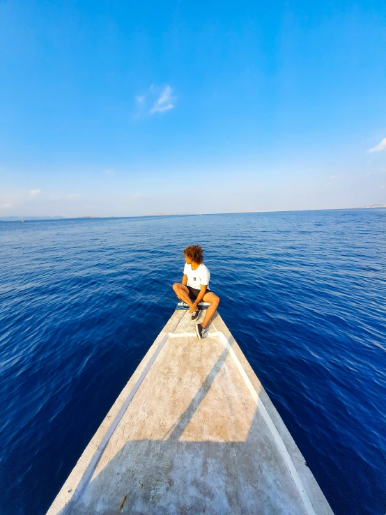 a man sitting on top of a boat in the middle of the ocean, profile image