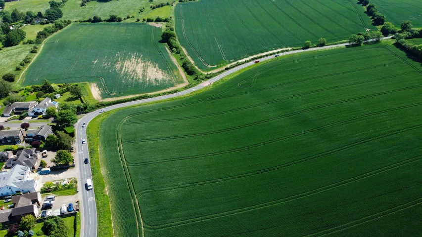 an aerial view of a large green field, pexels contest winner, roadside, looking partly to the left, geomorphology, stubbles