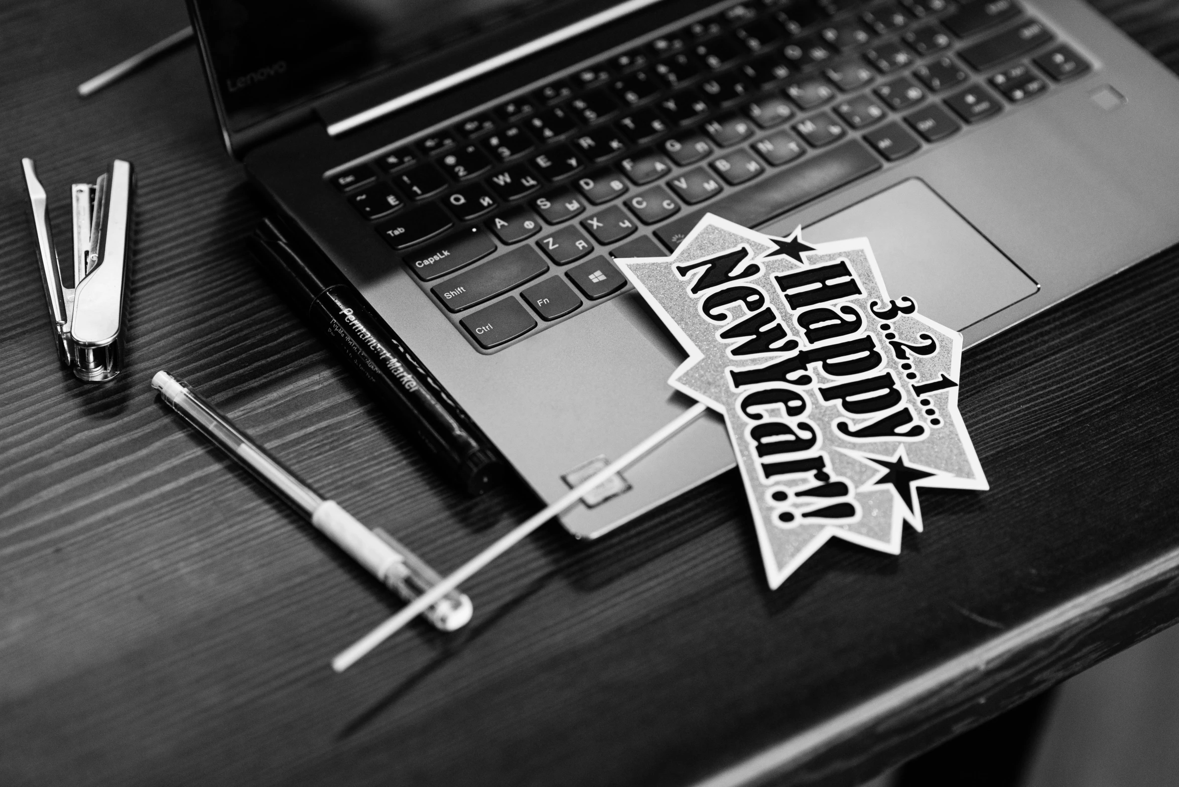 a laptop computer sitting on top of a wooden desk, a black and white photo, computer art, new years eve, sticker - svg, ad image