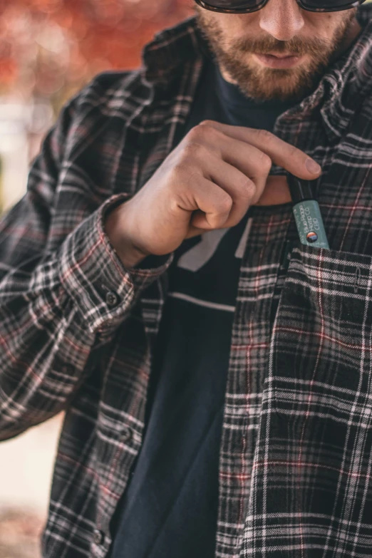 a close up of a person wearing a jacket and sunglasses, by Jan Tengnagel, unsplash, holding a small vape, wearing plaid shirt, wearing several pendants, teal