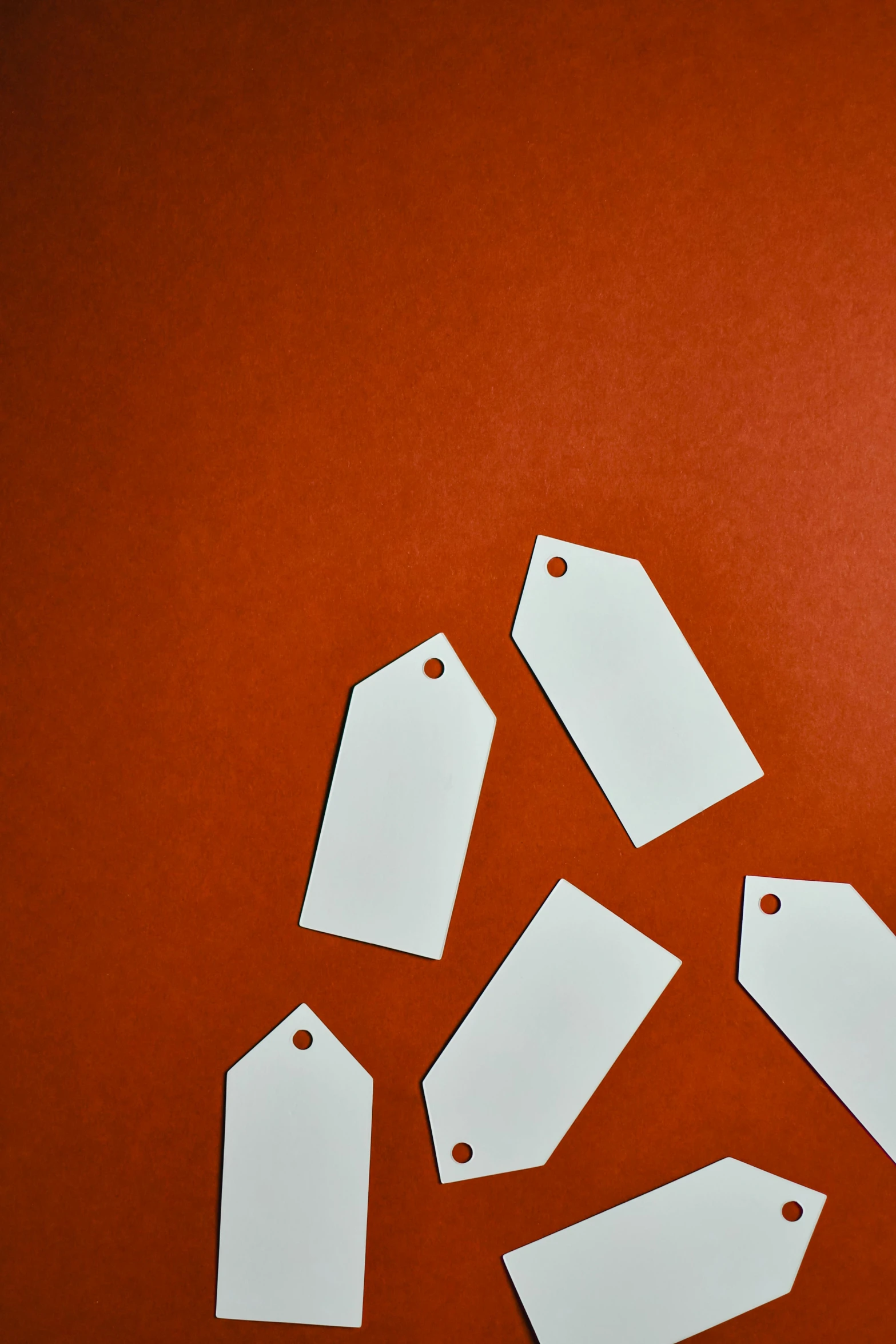 a bunch of tags sitting on top of a table, pexels contest winner, on a red background, empty edges, paper cutout, angular minimalism