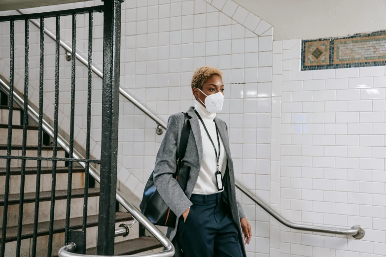 a woman wearing a face mask in a subway station, by Nina Hamnett, pexels contest winner, afrofuturism, wearing a white button up shirt, technical suit, a blond, nyc