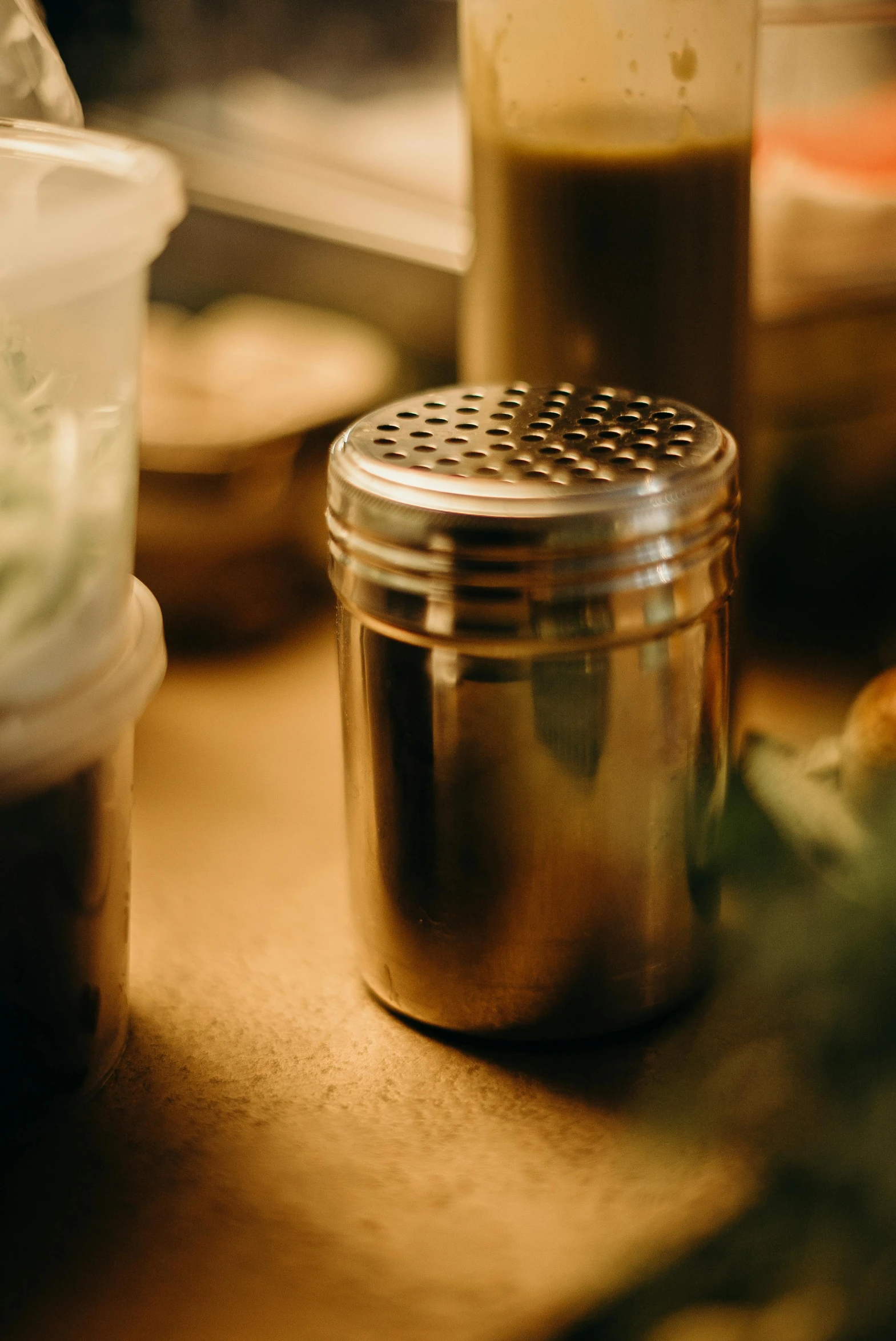 a close up of a container of food on a table, a still life, unsplash, process art, stainless steel, brown, tall, herbs