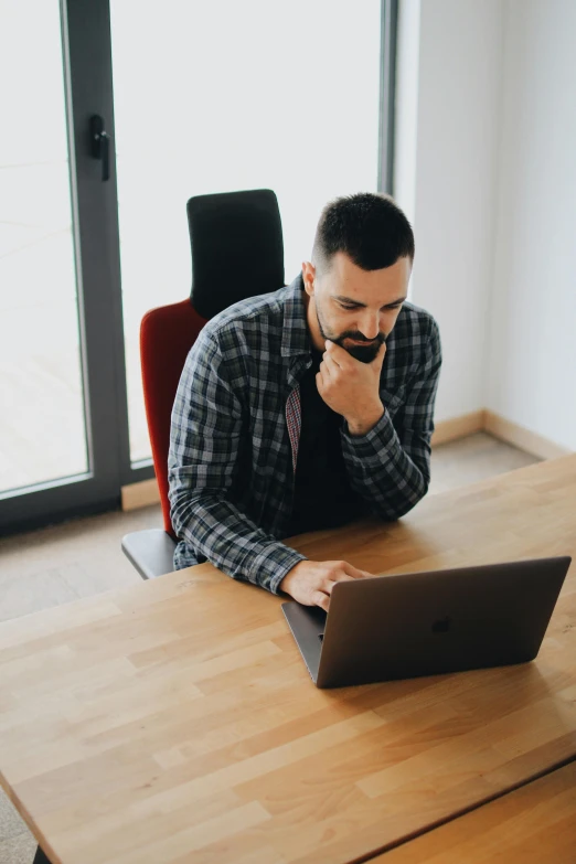 a man sitting at a table with a laptop, profile image, 2019 trending photo, a high angle shot, looking confused