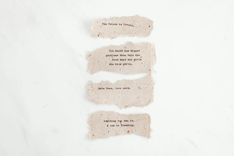 three pieces of paper sitting on top of a table, inspired by Elsie Few, unsplash, conceptual art, concrete poetry, ashes, on white background, instagram story
