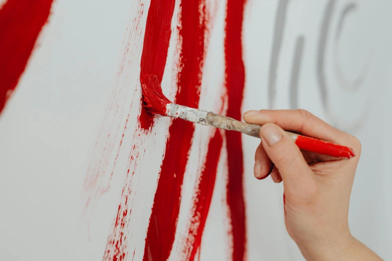 a woman is painting an american flag on a wall, a photorealistic painting, inspired by Philip Guston, trending on pexels, action painting, red ink, the color red, arbeitsrat fur kunst, lacquer on canvas