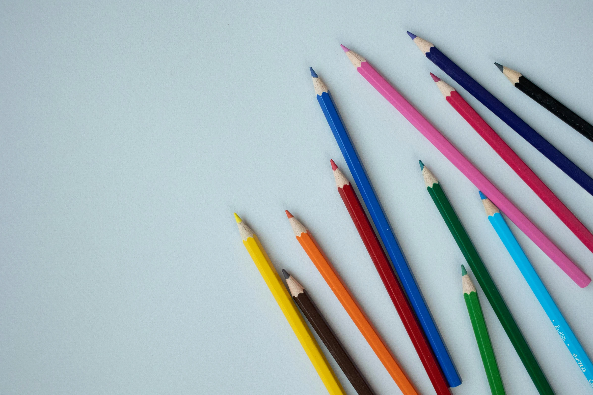 a group of colored pencils sitting next to each other, a child's drawing, by Carey Morris, pexels, visual art, on a pale background, blue background colour, very elongated lines, opening shot