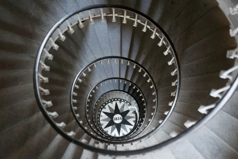 a spiral staircase with a compass on the top, pexels contest winner, grey, hannah af klint, staggered depth, birdseye view
