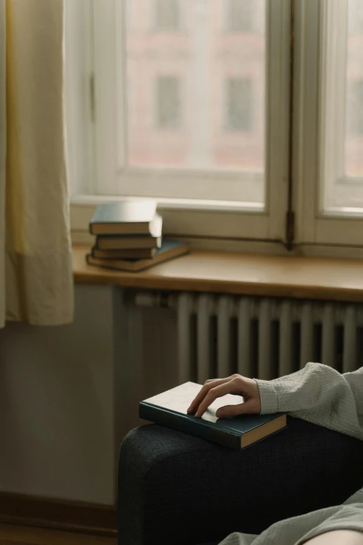 a woman sitting in a chair reading a book, inspired by Elsa Bleda, pexels contest winner, academic art, soft light.4k, window, holding a stack of books, typing on laptop