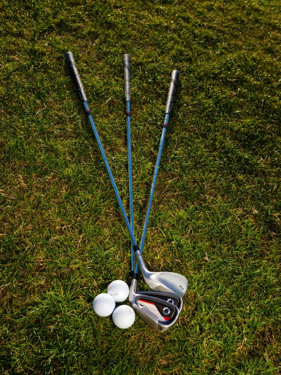 a couple of golf clubs sitting on top of a lush green field