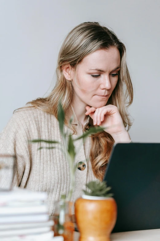 a woman sitting in front of a laptop computer, a portrait, pexels, blonde swedish woman, profile image, thoughtful )