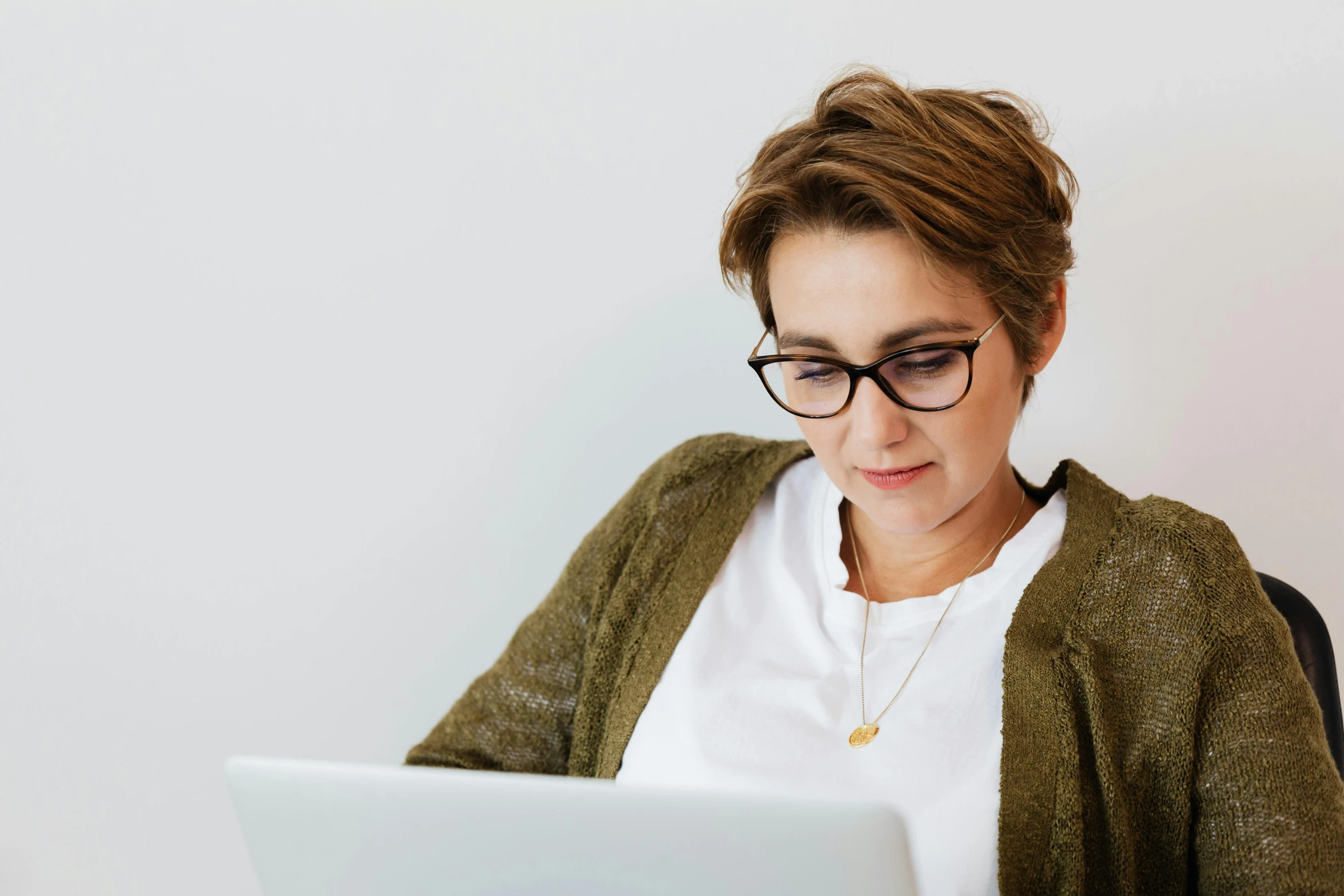 a woman sitting in front of a laptop computer, trending on pexels, wearing black rimmed glasses, avatar image, caucasian, decorative