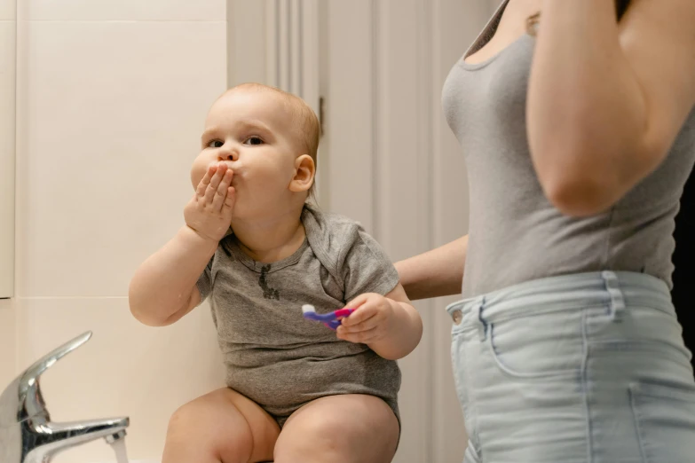 a woman brushing a baby's teeth in a bathroom, pexels contest winner, happening, hand on his cheek, grey, head to waist, upscaled to high resolution