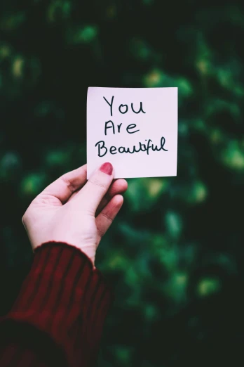 a person holding a piece of paper with the words you are beautiful written on it, a polaroid photo, by Julia Pishtar, pexels contest winner, aestheticism, photo of a beautiful, beautiful - n 9, kindness, an impeccable beauty