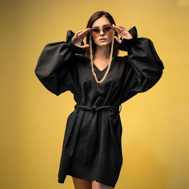 a woman in a black dress and sunglasses, inspired by Elsa Bleda, pexels contest winner, golden tech robes, lucy hale, voluminous sleeves, black jewelry