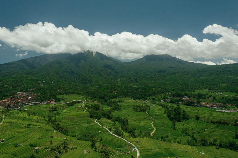 a lush green field with mountains in the background, by Daren Bader, pexels contest winner, sumatraism, birds - eye view, panorama, slide show, conde nast traveler photo