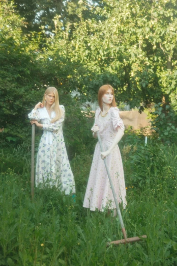 a couple of women standing on top of a lush green field, an album cover, inspired by Konstantin Somov, magic realism, sullen old maid ( redhead, 2019 trending photo, porcelain japanese mannequins, midsommar - t